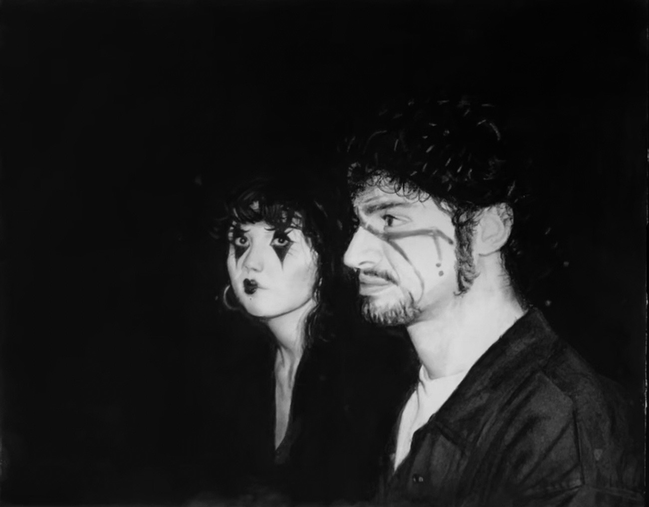 A charcoal drawing of two people staring at the viewer. The woman is wearing mime makeup, while the man is wearing makeup inspired by Serj Tankian.